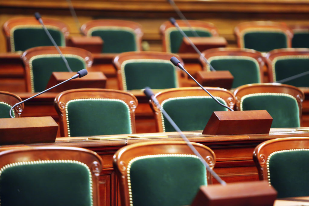 Empty vintage congress hall with seats and microphones.
